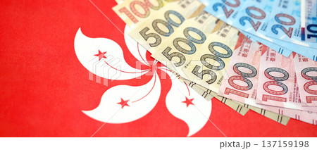 Big pile of Hong Kong dollars money bills banknotes on red flag. Lots of money of Chinese Hong Kong HKD currency cash. Economics and business in HongKong 137159198