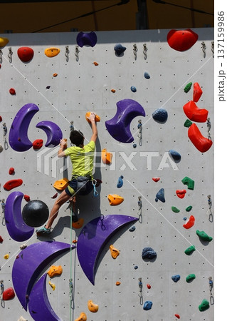 ボルダリングで壁を登る選手 137159986