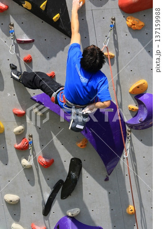 ボルダリングで壁を登る選手 137159988