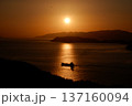 海に沈む夕日と照らされる小舟 137160094