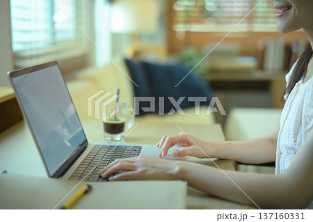 Closeup woman's hands using laptop computer on desk 137160331