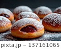 Close-up of sufganiot filled with jam and dusted with powdered sugar at a festive gathering 137161065