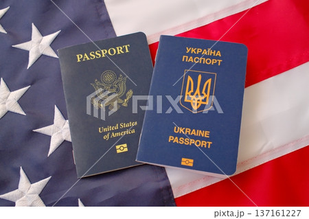 United States and Ukrainian passports on American flag background, dual citizenship and international travel concept 137161227