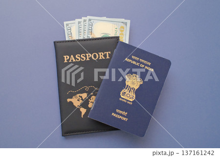 India passport with US dollar banknotes in leather cover on gray background, travel and immigration finance concept India passport with US dollar banknotes in leather cover on gray background, travel and immigration finance concept 137161242