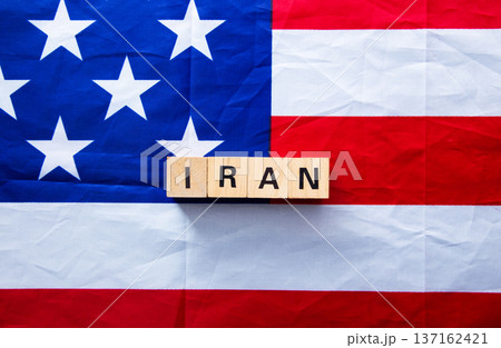 Iran wooden blocks on american flag showing conflict 137162421