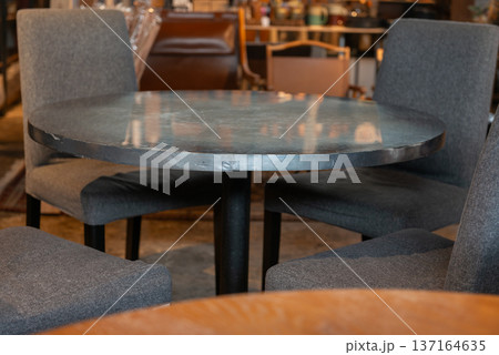 カフェの円卓とグレーの椅子 落ち着いた色合いのモダンなインテリアと円形テーブルのセット カフェの円卓とグレーの椅子 落ち着いた色合いのモダンなインテリアと円形テーブルのセット 137164635