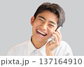 笑顔で電話する男性 137164910