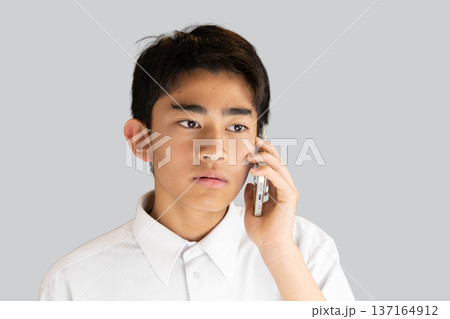 スマホで電話する男子学生 137164912