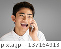 スマホで通話する笑顔の学生 137164913
