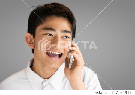 スマホで通話する笑顔の学生 137164913