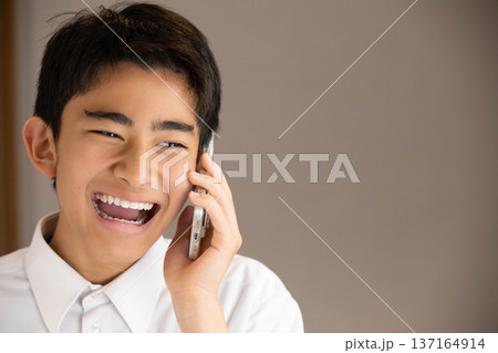 スマホで通話する笑顔の学生 137164914