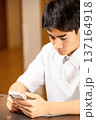 家でスマホを見る学生 137164918