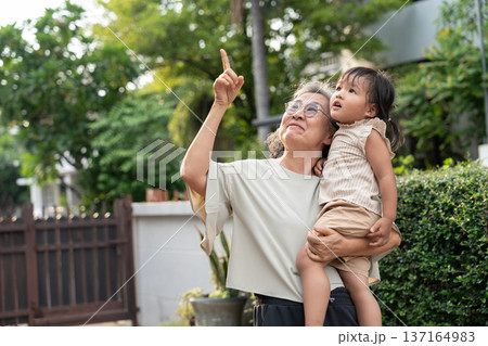A cheerful grandmother embraces her granddaughter in the home, sharing a special moment. Their bond reflects love, care, and cherished memories, celebrating family joy and the enjoyment of retirement A cheerful grandmother embraces her granddaughter in the home, sharing a special moment. Their bond reflects love, care, and cherished memories, celebrating family joy and the enjoyment of retirement 137164983