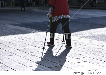 日本の東京都市景観杖の高齢女性….東京マラソン開催日の日本橋・「三越前駅」前の歩道で 137165540