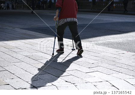 日本の東京都市景観杖の高齢女性….東京マラソン開催日の日本橋・「三越前駅」前の歩道で 137165542