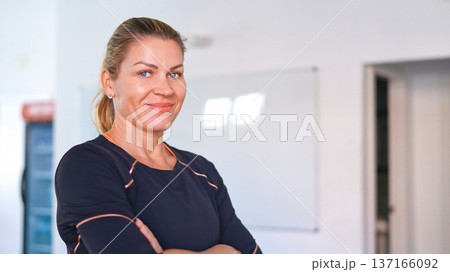 Woman smiling with arms crossed in sportswear looking at camera 137166092
