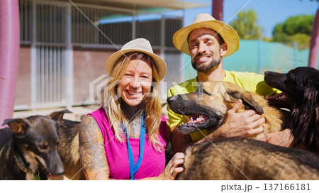 Volunteers smiling, embracing rescued dogs at an animal shelter 137166181
