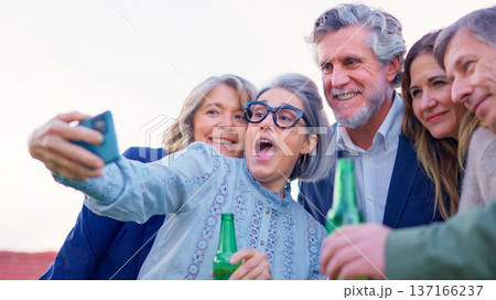 Mature friends drinking beer and taking a selfie outdoors 137166237