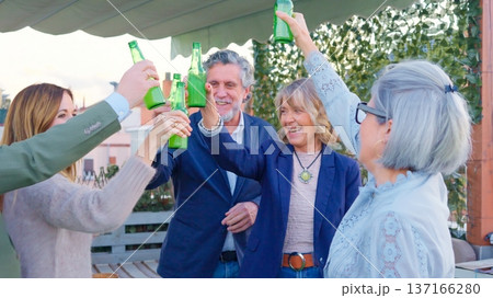 Friends toasting with bottles enjoying rooftop party Friends toasting with bottles enjoying rooftop party 137166280