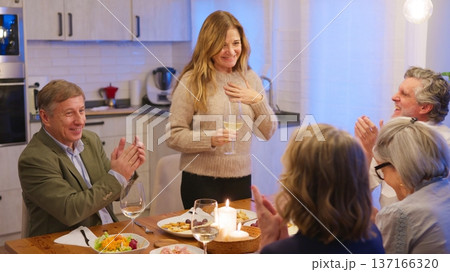 Woman making speech at dinner party with friends celebrating Woman making speech at dinner party with friends celebrating 137166320