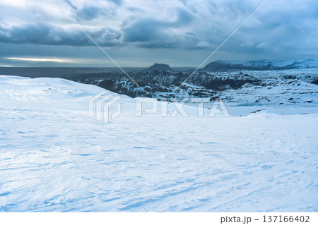 White glacier mountain with snowmobile track on summit in winter 137166402