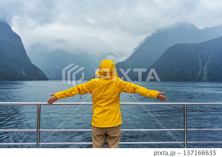 Tourist woman enjoying the view of Milford Sound during ferry cruise on vacation Tourist woman enjoying the view of Milford Sound during ferry cruise on vacation 137166635