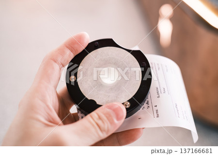 Hand holding queue calling with paper receipt after buying coffee 137166681