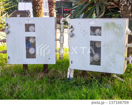 Water meters in the park. Calculating water waste. Utility payment concept. 137166709