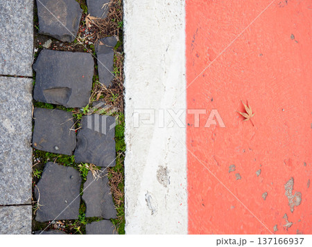 Border between running track and street paving stones. Treadmill concept. Surface for cycling. Infrastructure of a modern city. 137166937