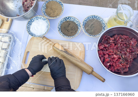The family prepares the Uzbek national dish manti, top view. The family prepares the Uzbek national dish manti, top view. 137166960