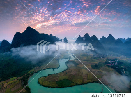 Sunrise over mountain range with foggy on rural village and river flows through in Phong Nam Valley at Vietnam Sunrise over mountain range with foggy on rural village and river flows through in Phong Nam Valley at Vietnam 137167134