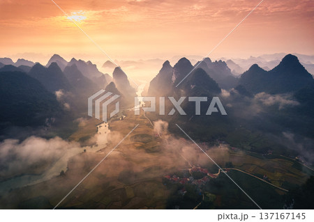 Golden sunrise over mountain range with foggy on rural village and river flows through in Phong Nam Valley at Cao Bang, Vietnam Golden sunrise over mountain range with foggy on rural village and river flows through in Phong Nam Valley at Cao Bang, Vietnam 137167145