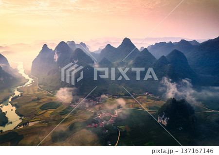 Beautiful sunrise over mountain range with foggy on rural village in Phong Nam Valley at Cao Bang, Vietnam Beautiful sunrise over mountain range with foggy on rural village in Phong Nam Valley at Cao Bang, Vietnam 137167146