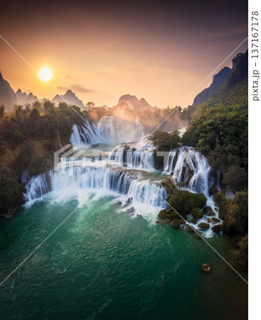 Majestic Ban Gioc waterfall, Detian Falls flowing in tropical forest during the sunset at Cao Bang, Vietnam Majestic Ban Gioc waterfall, Detian Falls flowing in tropical forest during the sunset at Cao Bang, Vietnam 137167178