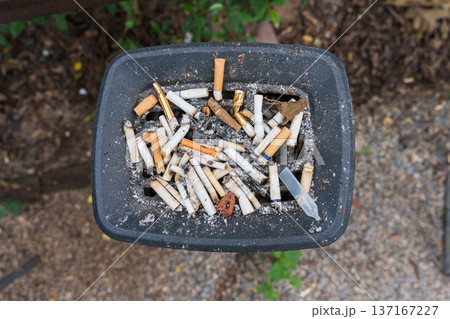 Ashtray filled with many used cigarette butts and ashes, smorking filter and health concerns Ashtray filled with many used cigarette butts and ashes, smorking filter and health concerns 137167227