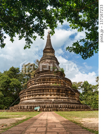 Ancient buddhist stupa of Wat Umong Suan Puthatham surrounded by lush green leaves in Chiang Mai Ancient buddhist stupa of Wat Umong Suan Puthatham surrounded by lush green leaves in Chiang Mai 137167233