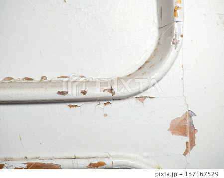 Part of an old door. White paint is coming off the wood. Surface with peeling paint. Part of an old door. White paint is coming off the wood. Surface with peeling paint. 137167529