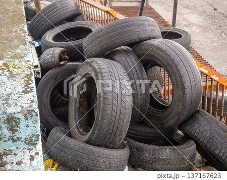 pile of dumped used car tires. Lots of rubber. Tire dump. Industrial zone. Next to the auto repair shop. pile of dumped used car tires. Lots of rubber. Tire dump. Industrial zone. Next to the auto repair shop. 137167623