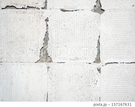 background of broken white tiles. The wall needs repairs. The concept of ruin and abandonment. Chipped tile. 137167631