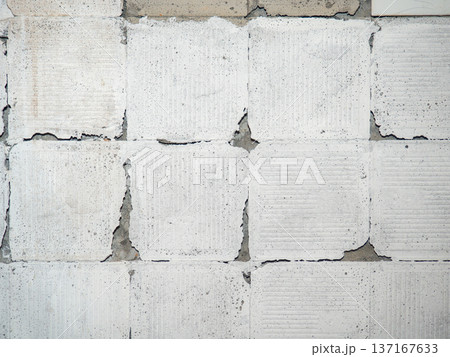 background of broken white tiles. The wall needs repairs. The concept of ruin and abandonment. Chipped tile. background of broken white tiles. The wall needs repairs. The concept of ruin and abandonment. Chipped tile. 137167633