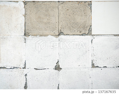 background of broken white tiles. The wall needs repairs. The concept of ruin and abandonment. Chipped tile. background of broken white tiles. The wall needs repairs. The concept of ruin and abandonment. Chipped tile. 137167635