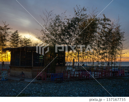 Restaurant on the seashore at sunset. sea coastal landscape. Restaurant at the resort. A thatched hut surrounded by bamboo. 137167735