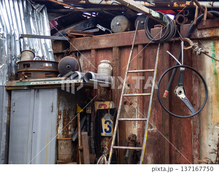 In an old auto repair shop. Rusty spare parts and machine elements. Abandoned car mechanic's office. Corrosion on spare parts. 137167750