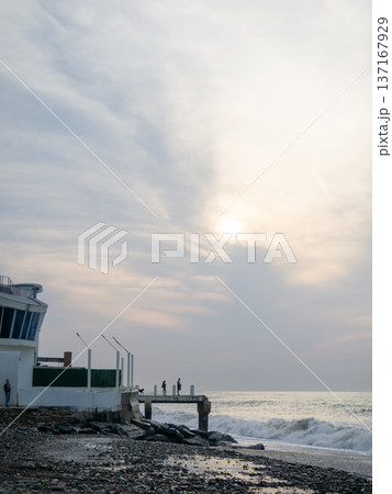 Destroyed pier under the waves. Bad weather at sea. Beautiful seashore with old architecture. Destroyed pier under the waves. Bad weather at sea. Beautiful seashore with old architecture. 137167929