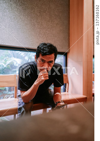 Thoughtful Man Looking Directly at Camera in Indoor Setting 137168162