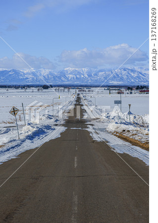 北海道の雪原を一直線に伸びる道と雪山の絶景風景 北海道の雪原を一直線に伸びる道と雪山の絶景風景 137168269