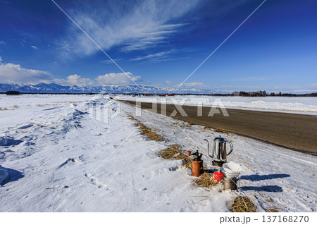 冬の北海道・十勝平野の一本道と青空の下で楽しむ雪原コーヒー時間 137168270