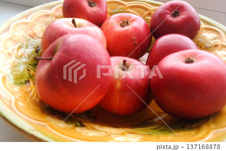 Apples on a yellow plate. 137168878