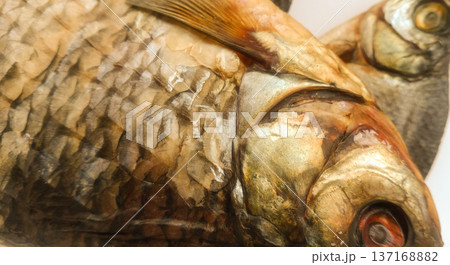 Two dry fish on a white sheet of paper. Two dry fish on a white sheet of paper. 137168882