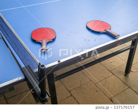 Ping pong tables in the park. Table tennis rackets on a table in the park. The concept of the end of the game. holiday at the resort. 137170157
